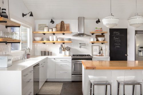 A kitchen with white cabinets and wooden counters.