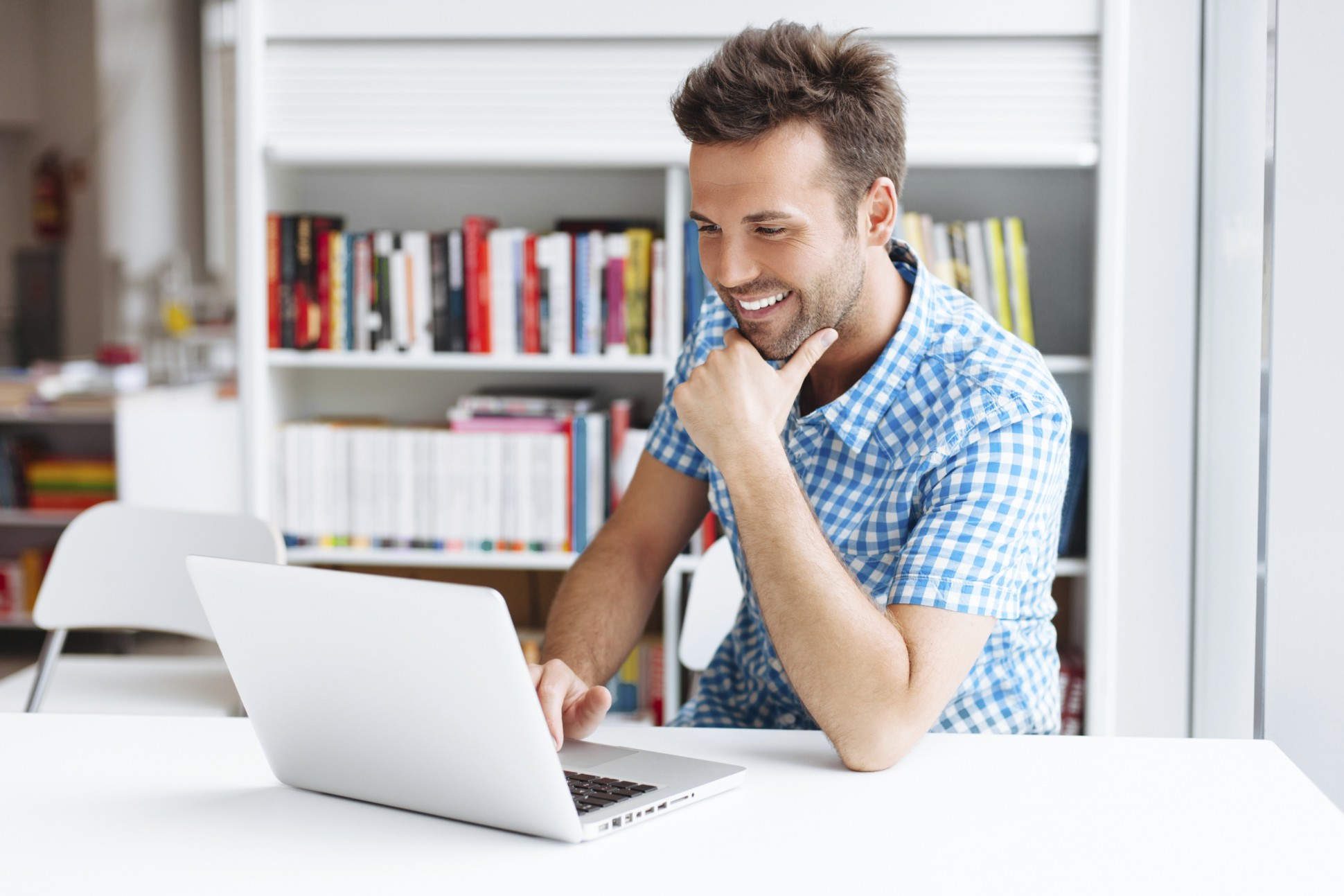 A man sitting at a table with his laptop.