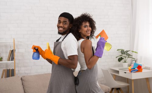 A man and woman holding cleaning supplies in their hands.