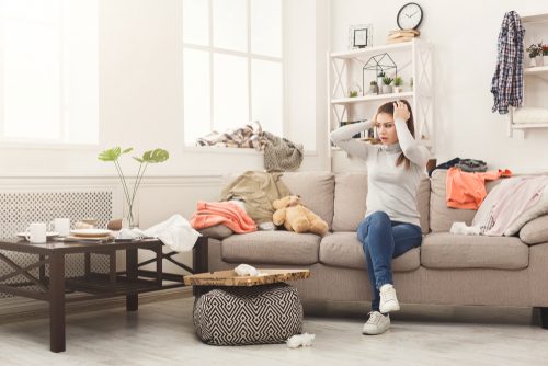 A woman sitting on top of a couch in a living room.