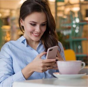 A woman sitting at a table with a cup of coffee.