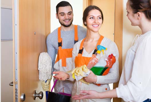 A man and woman holding cleaning supplies in their hands.